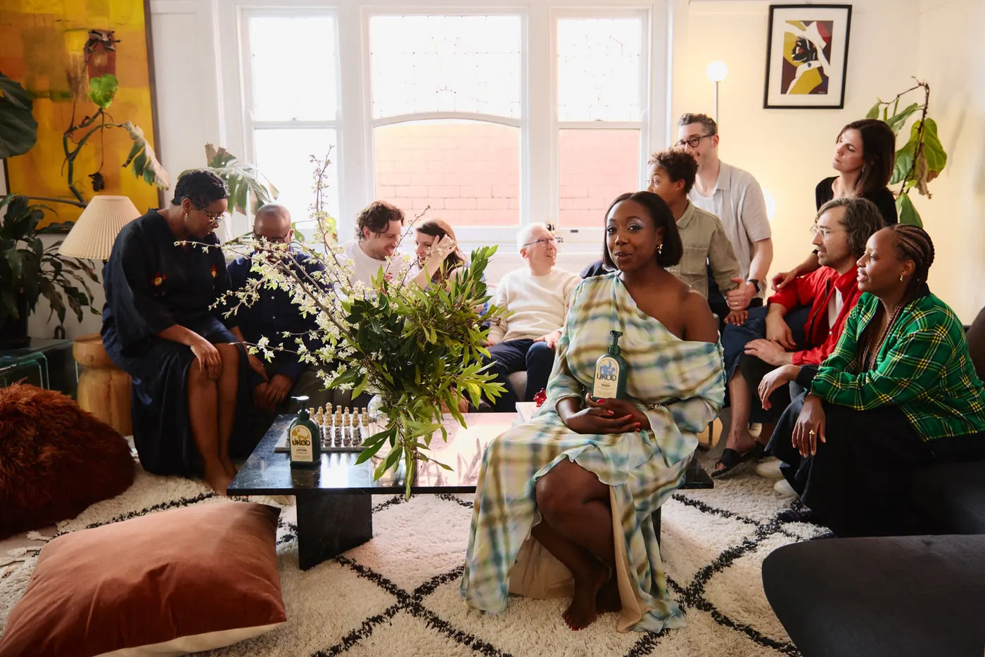 UKOO founder holding a bottle of body wash, surrounded by friends and family at the UKOO launch