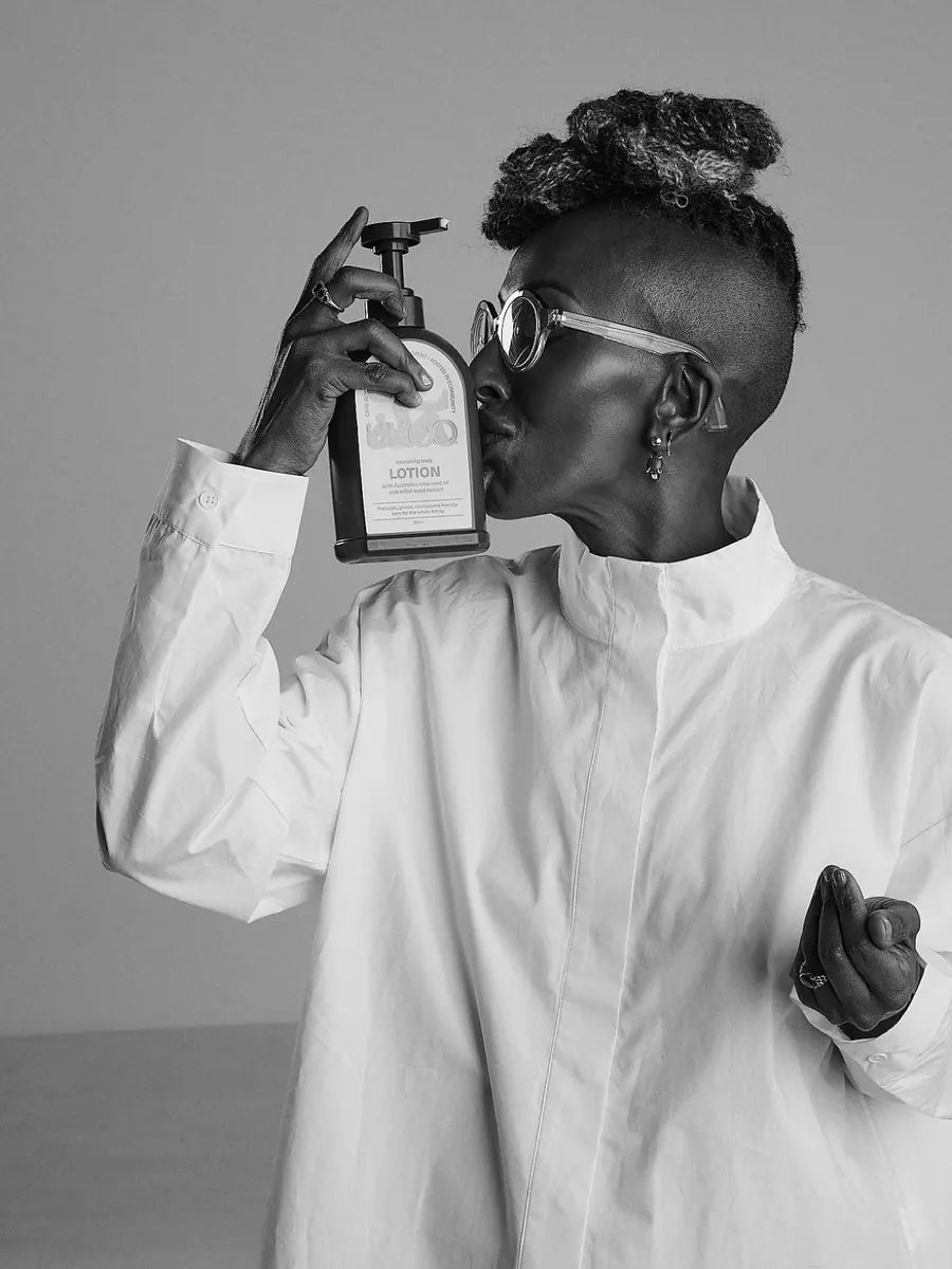 Black and white portrait from The Matriarchs series: Dr. Edna Lekgabe holding a bottle of UKOO